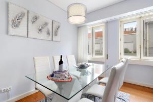 een eetkamer met een glazen tafel en witte stoelen bij Apartment Boutique Santa Catarina 2 in Porto