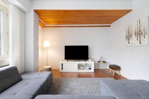 een woonkamer met een bank en een flatscreen-tv bij Apartment Boutique Santa Catarina 2 in Porto