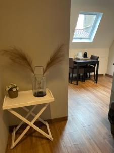 una mesa con un jarrón al lado de una habitación en De Stadspoort appartementen en Aardenburg