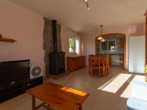 a living room with a tv and a stove at INNOUTHOME CASA CON PISCINA Av AMETLLA DE MAR in L'Ametlla de Mar