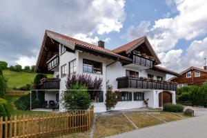 Casa blanca con balcones negros y valla en Freigeist, en Nesselwang