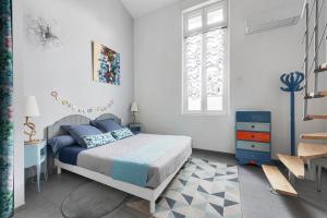 een witte slaapkamer met een bed en een raam bij Au Nid de la Madeleine in Gaillac