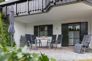 un patio con mesa, sillas y sombrilla en Freigeist, en Nesselwang