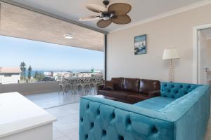 a living room with a couch and a ceiling fan at Shanthi Apartment 3 in Ballito