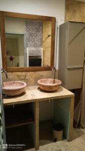 dois lavatórios em cima de um balcão com um espelho em maison Jonquière millet em Jonquières
