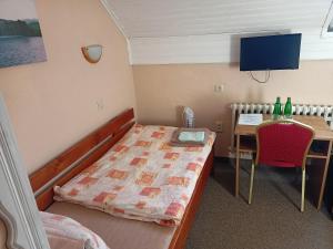 a small room with a bed and a table with bottles at Hotel Koloniál Skalité in Skalité