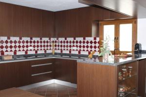 a kitchen with red and white tile on the wall at Casa das Argolas in Macedo de Cavaleiros