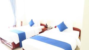 a room with three beds and a window at Navy Hotel Cam Ranh in Cam Ranh