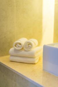 - une pile de serviettes sur un comptoir dans la salle de bains dans l'établissement Navy Hotel Cam Ranh, à Cam Ranh