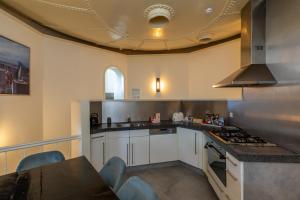 een keuken met een wastafel en een fornuis top oven bij Watertoren - Molenwater 2a Middelburg in Middelburg