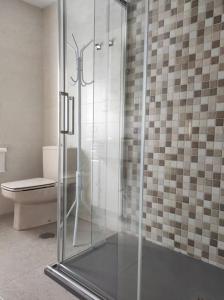 a bathroom with a glass shower with a toilet at Casa Loli-Villar in Luarca