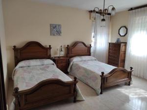 two beds sitting next to each other in a bedroom at Casa Loli-Villar in Luarca