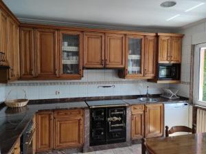 a kitchen with wooden cabinets and a counter top at Casa Loli-Villar in Luarca +13 photos