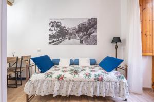a bedroom with a bed with blue pillows at Alla Marina Monolocale Deluxe in Cagliari