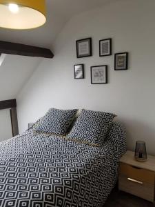 een slaapkamer met een bed en wat foto's aan de muur bij Le Toit de Bigorre - T2 - Bagnères de Bigorre in Bagnères-de-Bigorre