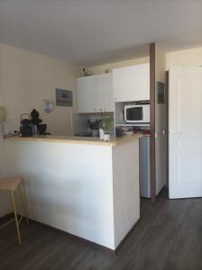 uma cozinha com um balcão branco e um micro-ondas em Appartement face Mer em Tréboul