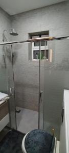 a shower with a glass door in a bathroom at The Oaks in Madaba