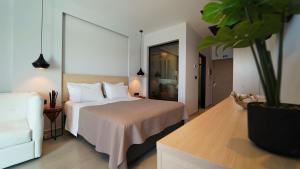 a hotel room with a bed and a potted plant at Enjoy Lichnos Bay Village, Camping, Hotel and Apartments in Parga