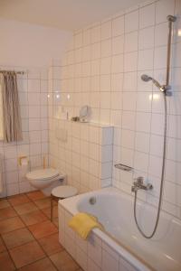 uma casa de banho branca com uma banheira e um WC em Landhaus am Esch em Warendorf