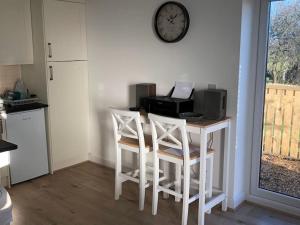 a kitchen with a table with chairs and a clock on the wall at Springwood farm in Kirkhamgate +11 photos
