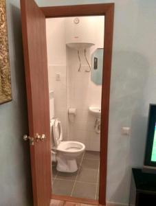 a bathroom with a white toilet in a room at Apartment On Knyazya Romana 26 Center Lviv in Lviv