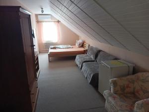 a living room with a couch and a bed at Hotel Koloniál Skalité in Skalité