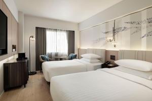 a hotel room with two beds and a television at Courtyard by Marriott Tokyo Ginza Hotel in Tokyo
