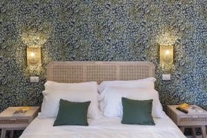 a bedroom with a bed with two tables and two lamps at Hotel Villa Lubrense Sorrento in Massa Lubrense