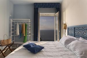 a bedroom with a bed with a view of the ocean at Hotel Villa Lubrense Sorrento in Massa Lubrense