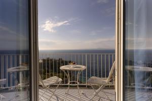 a balcony with a table and chairs and a view of the ocean at Hotel Villa Lubrense Sorrento in Massa Lubrense