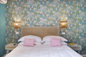 a bedroom with a bed with two pink pillows at Hotel Villa Lubrense Sorrento in Massa Lubrense