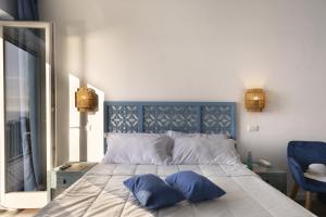 a bedroom with a bed with two blue pillows on it at Hotel Villa Lubrense Sorrento in Massa Lubrense