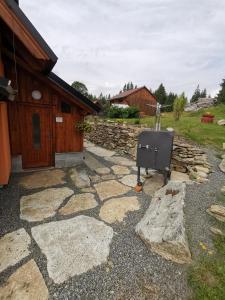 a stone patio with a grill in front of a building at Apartmán u Zdeňků in Modrava