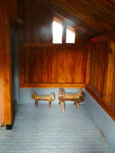 two benches sitting in a room with wooden walls at Apartmán u Zdeňků in Modrava