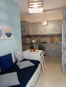 Cozy Studio in Beautiful Apollonas Beach Naxos في Apollon: مطبخ مع أريكة وطاولة في الغرفة