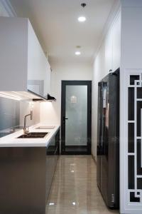 a kitchen with a sink and a black refrigerator at Monarchy Apartment in Da Nang
