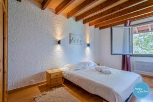 a bedroom with a white bed and a window at The Bergerie T3- View Mountains in La Pirraz
