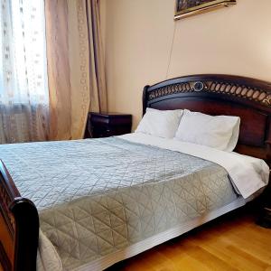 1 dormitorio con 1 cama grande y cabecero de madera en НОВОБУДОВА 2 кімнати Вернадського 8, en Leópolis