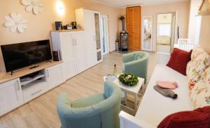 a living room with a couch and chairs and a tv at "Altes Stellwerk Frose" am Froser See in Frose