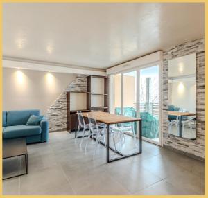 - un salon avec une table et un canapé bleu dans l'établissement Appartement T2 Moderne St Julien, à Saint-Julien-en-Genevois