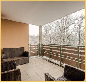 Elle comprend un balcon avec deux chaises et une grande fenêtre. dans l'établissement Appartement T2 Moderne St Julien, à Saint-Julien-en-Genevois