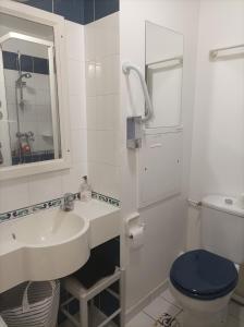 uma casa de banho com um lavatório e um WC em Appartement face Mer em Tréboul