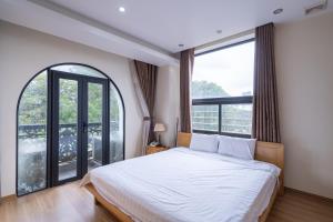 a bedroom with a bed and a large window at Cindy Hotel & Apartments - Khách Sạn Căn Hộ ở Trung Tâm TP Hải Phòng in Hai Phong