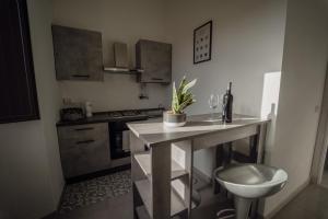 Una pequeña cocina con una mesa y un fregadero. en Casa Vacanze - Il Balconcino sul Castello, en Iglesias 9 fotos más