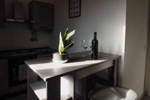 uma cozinha com uma mesa com uma planta e copos de vinho em Casa Vacanze - Il Balconcino sul Castello em Iglesias