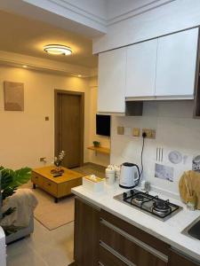 a kitchen with white cabinets and a stove top oven at 1bedroom Exquisite City Apartment in Kilimani by The Manna Stays in Nairobi