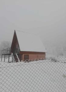 Une grange avec de la neige sur le toit dans l'établissement Seva Villa in Racha, à Oni