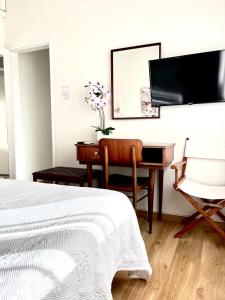Residencial Moderna في توريس فيدراس: غرفة نوم بسرير ومكتب وبيانو