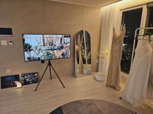 uma sala de estar com uma televisão de ecrã plano e vestidos em exposição em Moonlight Sonata em Bucheon