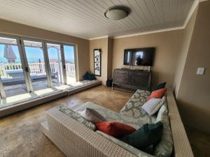 a living room with a couch and a large window at Leisure Lagoon View Langebaan in Langebaan